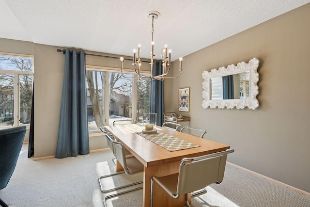 carpeted dining space featuring baseboards, a textured ceiling, and an inviting chandelier