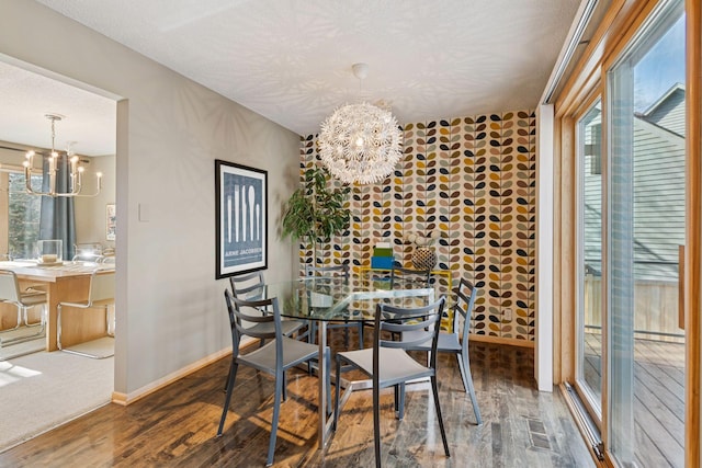 dining space with a notable chandelier, wood finished floors, baseboards, and a textured ceiling