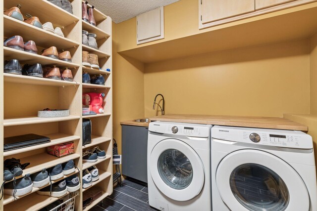 laundry area with washing machine and clothes dryer, laundry area, a textured ceiling, and a sink