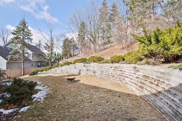 view of yard with fence and an outdoor fire pit