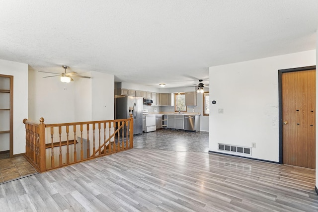 living room with visible vents, ceiling fan, baseboards, wood finished floors, and a textured ceiling