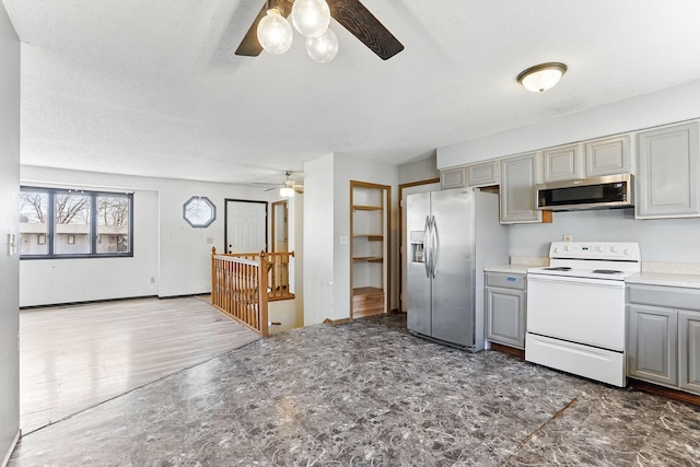 kitchen with gray cabinetry, light countertops, stainless steel appliances, a textured ceiling, and a ceiling fan