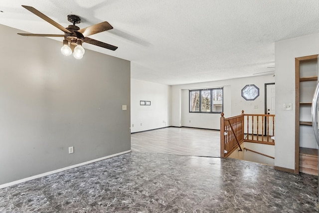 spare room with baseboards, a textured ceiling, and ceiling fan