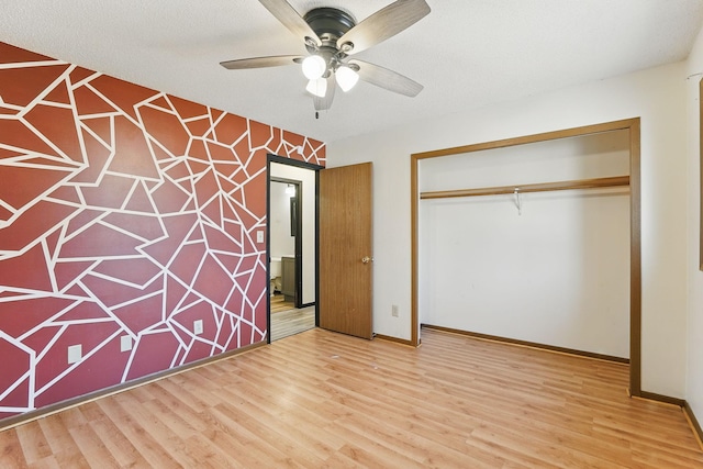 unfurnished bedroom featuring ceiling fan, wood finished floors, a closet, and baseboards