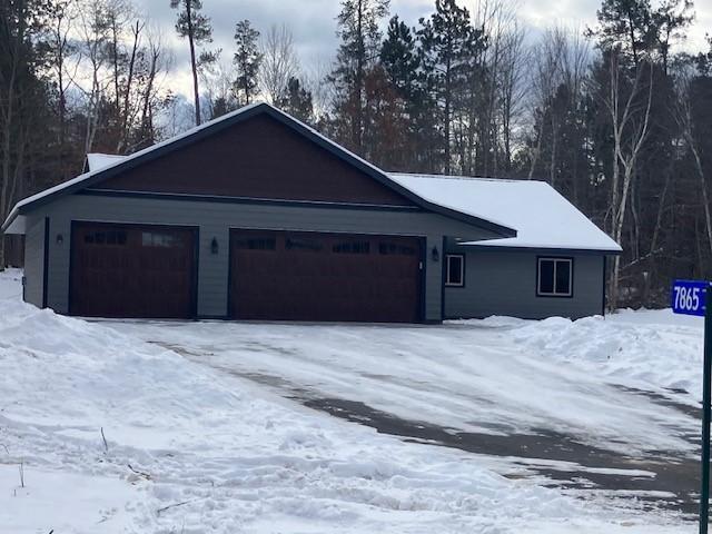 snow covered property with a garage