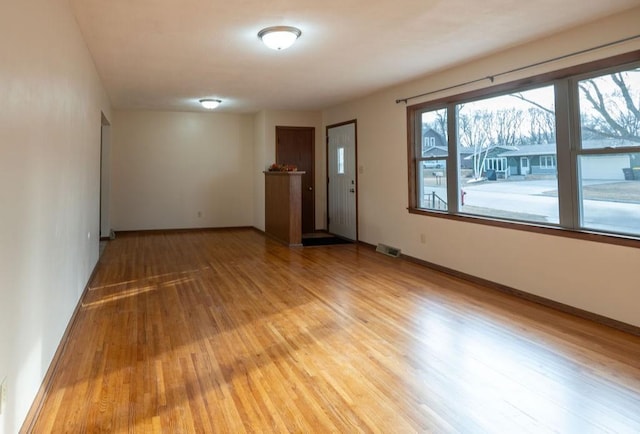 unfurnished room featuring visible vents, baseboards, and light wood-style flooring