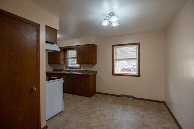 kitchen with a sink, visible vents, range, and baseboards