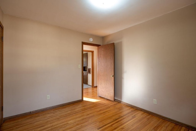 empty room with baseboards and light wood-style floors