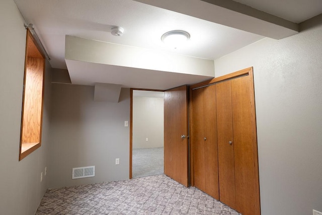 unfurnished bedroom with a closet, visible vents, and carpet floors