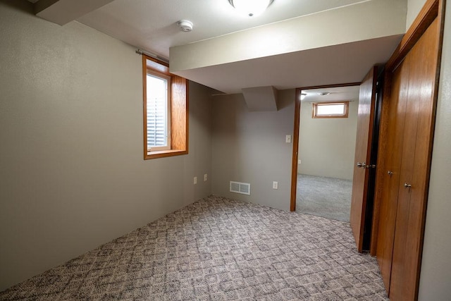 below grade area featuring visible vents and carpet floors