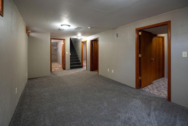 carpeted empty room with stairs and visible vents