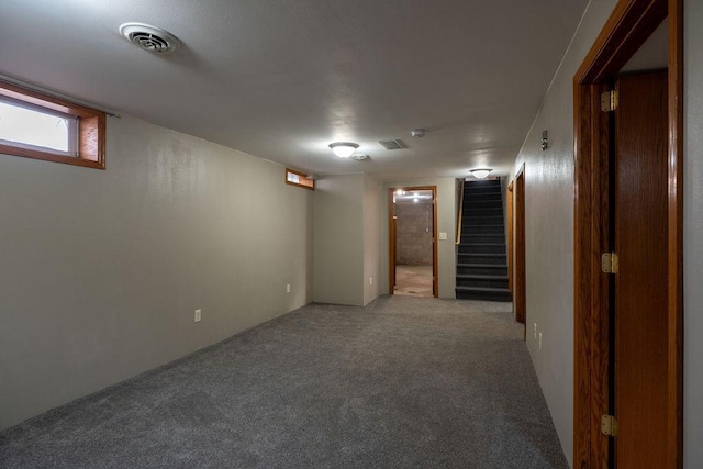 below grade area featuring stairway, carpet floors, and visible vents