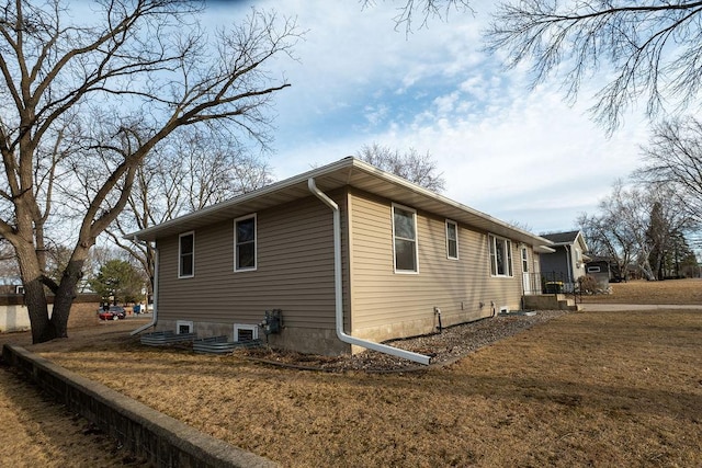 view of side of home with a yard