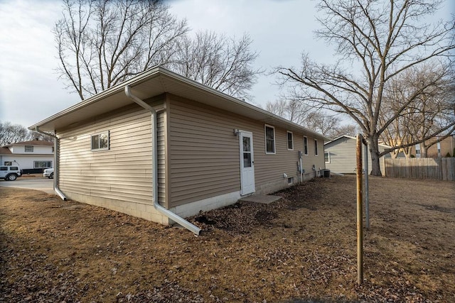 view of side of property with central air condition unit and fence