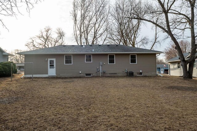 back of property featuring cooling unit and a shingled roof