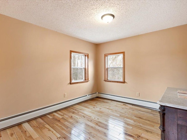 9529- 20th St, Saint Mathias Twp, MN 56449 - spare room with a textured ceiling, a baseboard radiator, and light wood-type flooring