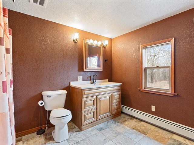 9529- 20th St, Saint Mathias Twp, MN 56449 - full bathroom with a baseboard heating unit, vanity, toilet, visible vents, and a textured ceiling