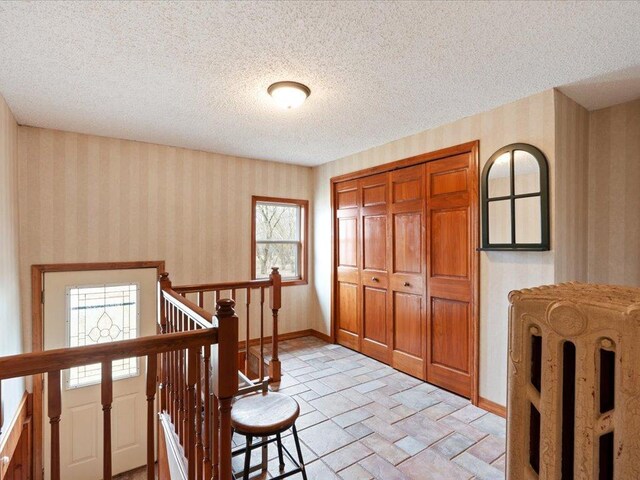 9529- 20th St, Saint Mathias Twp, MN 56449 - entrance foyer with baseboards, wallpapered walls, a textured ceiling, and stone finish floor