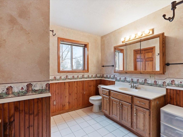 9529- 20th St, Saint Mathias Twp, MN 56449 - bathroom with vanity, toilet, wooden walls, tile patterned flooring, and wainscoting