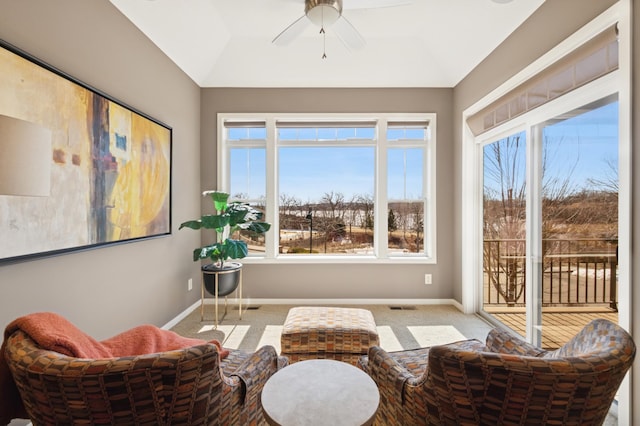 living area featuring a ceiling fan, visible vents, baseboards, and carpet floors