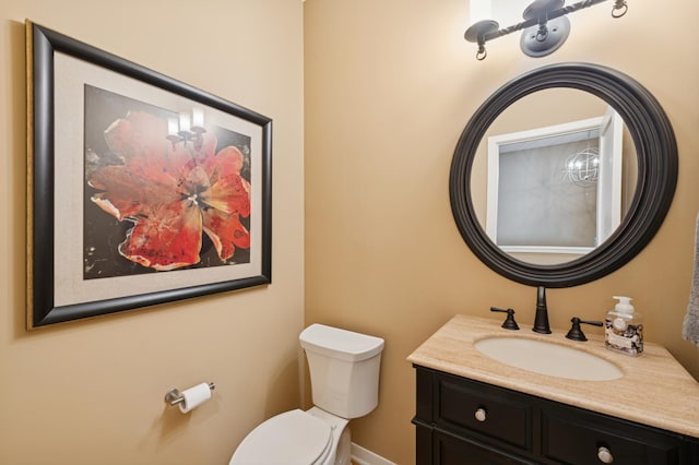 half bath featuring vanity and toilet