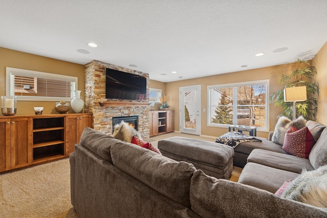 living area featuring recessed lighting, a stone fireplace, light colored carpet, and a textured ceiling