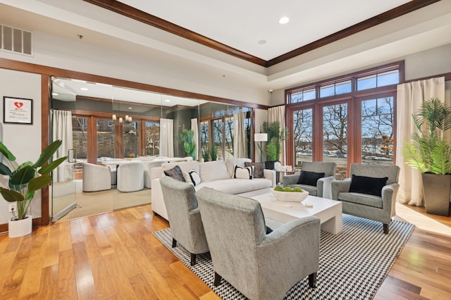 living room with recessed lighting, visible vents, light wood-style flooring, and ornamental molding