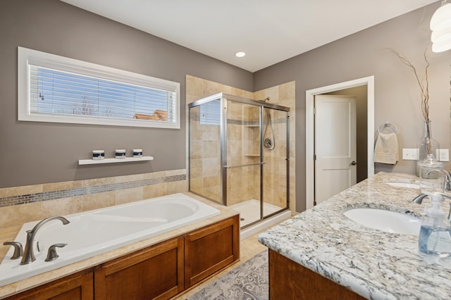 full bath with double vanity, a stall shower, a garden tub, and a sink