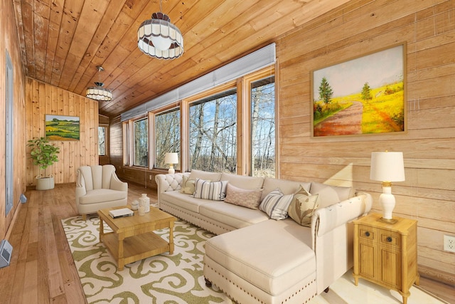 living area with visible vents, wood-type flooring, wooden walls, wooden ceiling, and lofted ceiling