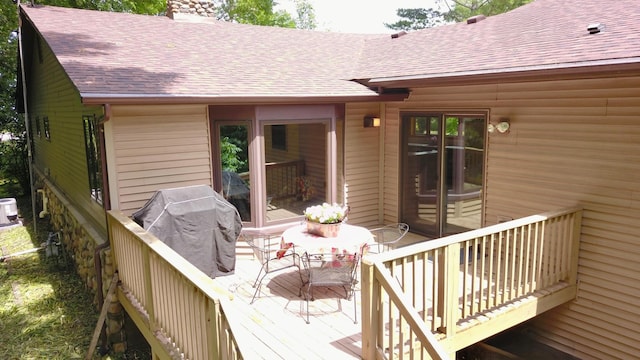 wooden terrace with outdoor dining area and central AC