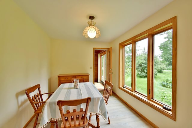 dining space featuring baseboards and light wood-style flooring