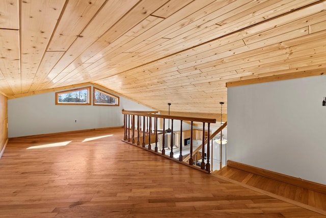 additional living space with wooden ceiling, wood finished floors, baseboards, and vaulted ceiling