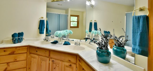 full bath with double vanity, a shower with shower curtain, and a sink