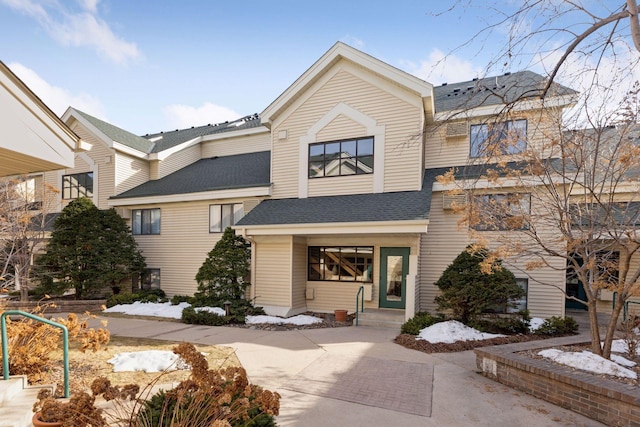 townhome / multi-family property featuring roof with shingles