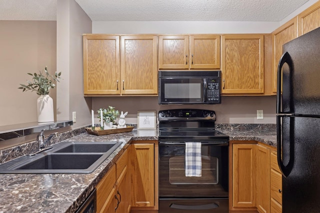 kitchen with a textured ceiling, black appliances, and a sink