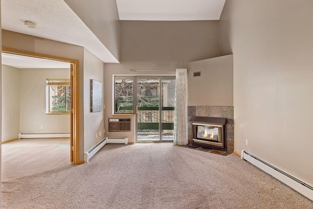 unfurnished living room with baseboard heating, a baseboard heating unit, carpet, and a wall unit AC