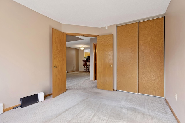 unfurnished bedroom featuring carpet flooring, baseboards, and a closet