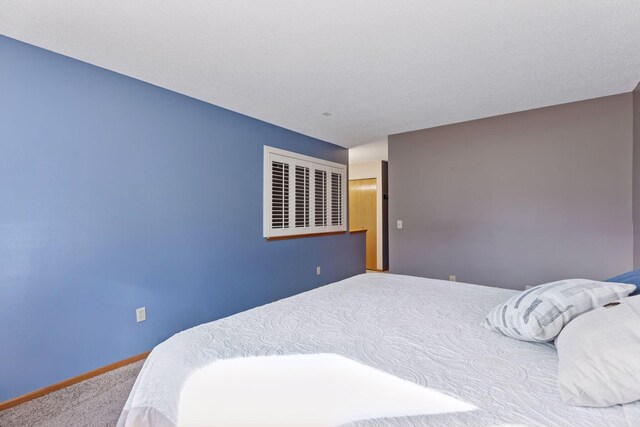 bedroom featuring carpet flooring and baseboards