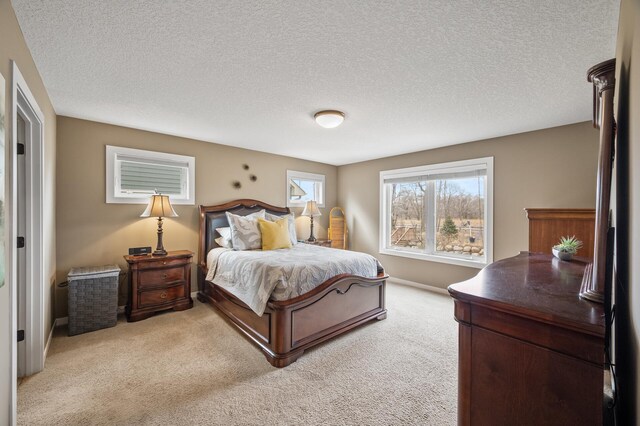 bedroom featuring baseboards, a textured ceiling, and light carpet