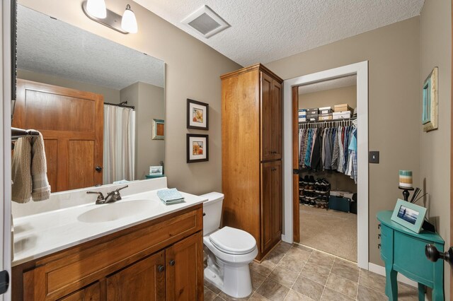 full bathroom featuring a textured ceiling, visible vents, toilet, vanity, and a shower with curtain