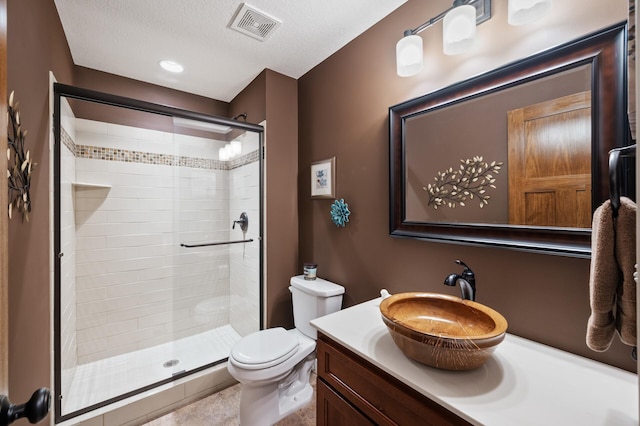full bathroom with a textured ceiling, visible vents, a shower stall, toilet, and vanity