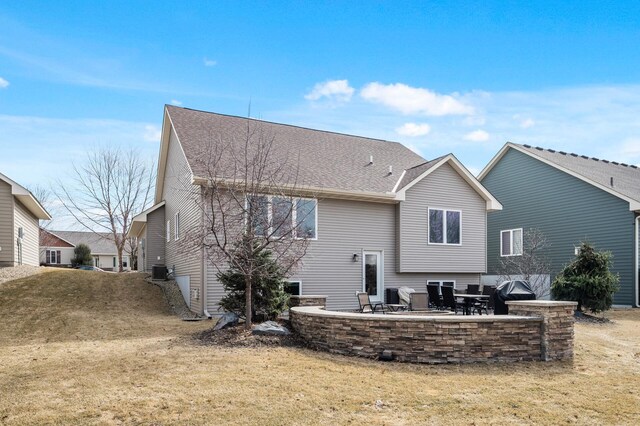 back of house featuring a yard, cooling unit, a patio area, and roof with shingles