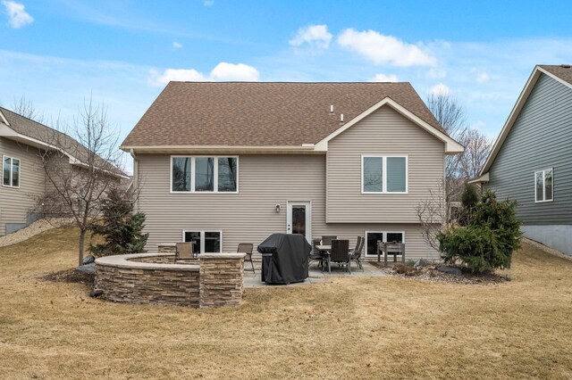 back of house with a patio, a shingled roof, and a yard