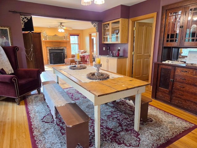 17634 240th St, Hutchinson Twp, MN 55350 - dining room featuring light wood-style flooring, a fireplace, and a ceiling fan