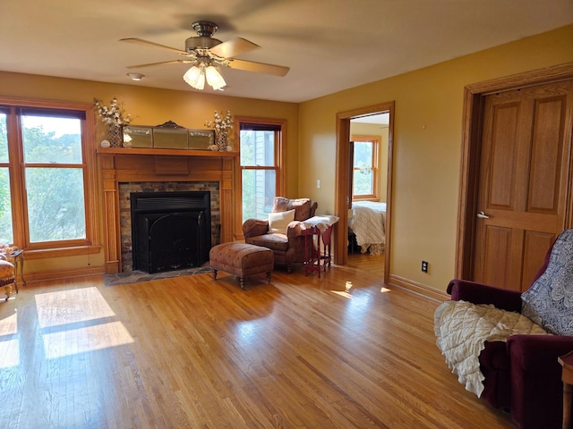 17634 240th St, Hutchinson Twp, MN 55350 - living room with light wood-style flooring, a stone fireplace, and ceiling fan