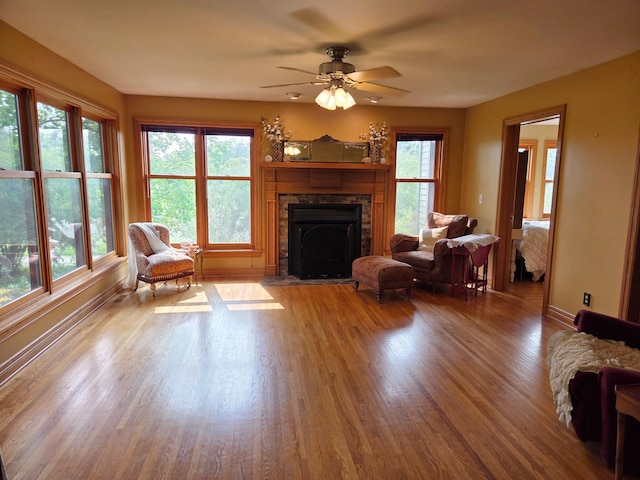 17634 240th St, Hutchinson Twp, MN 55350 - living area with a stone fireplace, wood finished floors, and a ceiling fan
