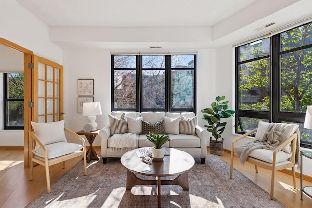 sunroom / solarium with visible vents, plenty of natural light, and french doors