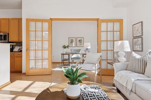 living area featuring french doors and light wood finished floors