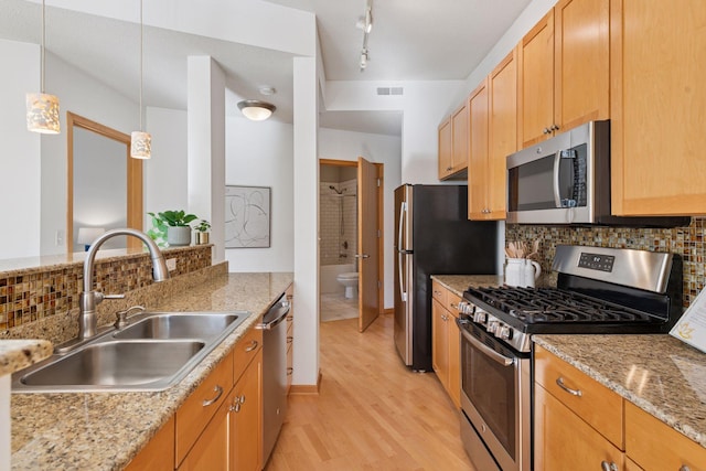 kitchen featuring visible vents, tasteful backsplash, a sink, light wood-style floors, and stainless steel appliances
