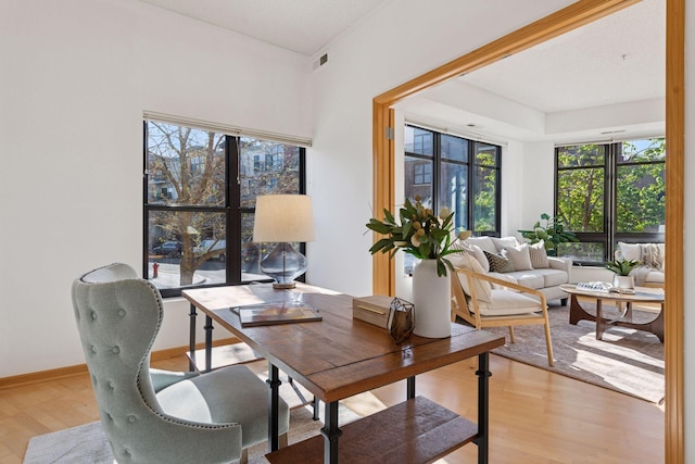 office featuring light wood-style floors, baseboards, and visible vents